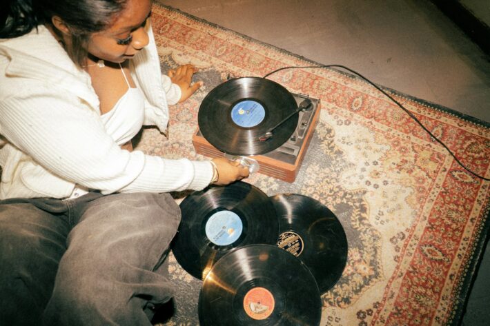 Woman placing a vinyl record on a turntable.